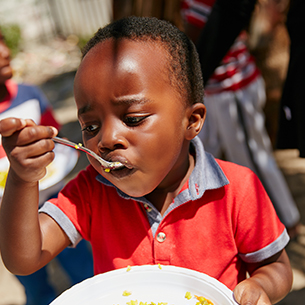 cropped-shot-of-children-getting-fed-at-a-food-out-FQPR2E8