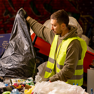 male-sorter-with-a-protective-vest-gloves-unloads--FGMERPF